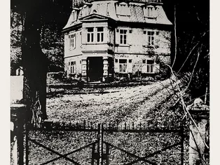 Historische Schwarz-Weiß-Fotografie des Schlössle Seeburg, aufgenommen vom Eingangsbereich mit Zufahrt und Garten.
