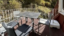 Sonnige Terrasse der Suite Nachtigall mit Sitzgruppe und Blick ins Grüne