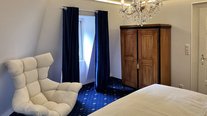 Suite Nachtigall mit komfortablem Designersessel, Kleiderschrank und warmem Lichtambiente